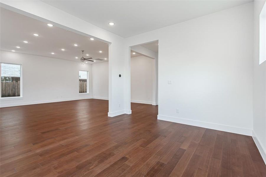 Unfurnished living room featuring ceiling fan and dark wood-type flooring