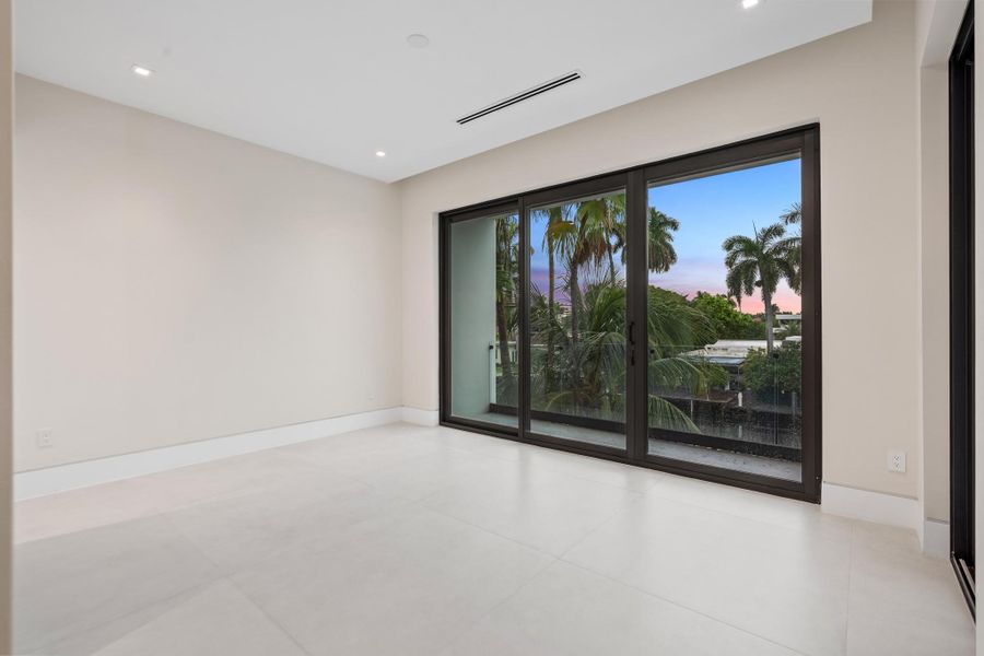Spacious bedroom with large sliding glass doors opening to a private balcony. Spacious bedroom with large sliding glass doors opening to a private balcony.
