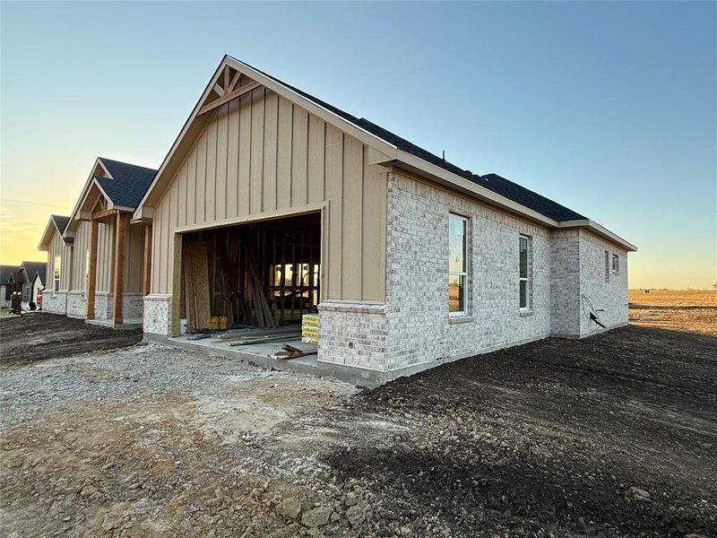 Property exterior at dusk with a garage and an outdoor structure