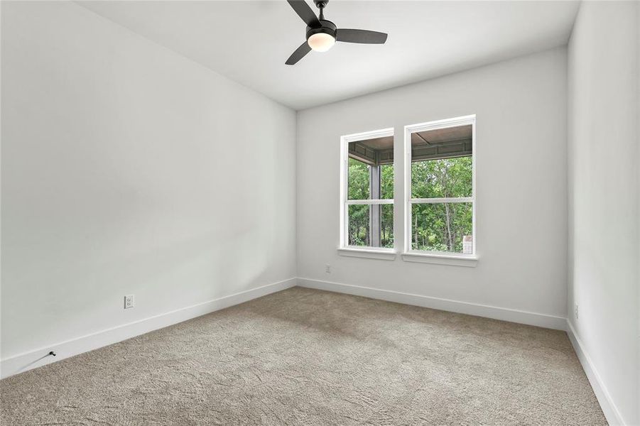 Empty room with carpet and a ceiling fan
