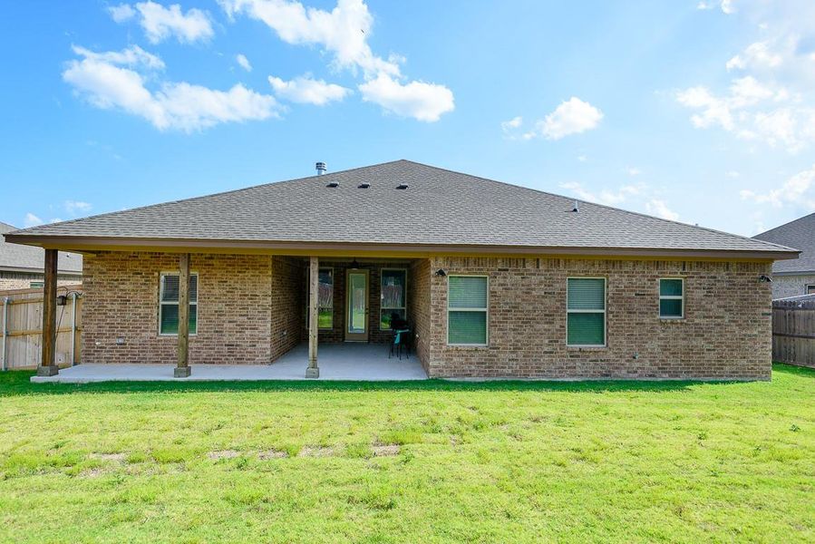 Rear view of property with brick siding, a patio, and roof with shingles Rear view of property with brick siding, a patio, and roof with shingles