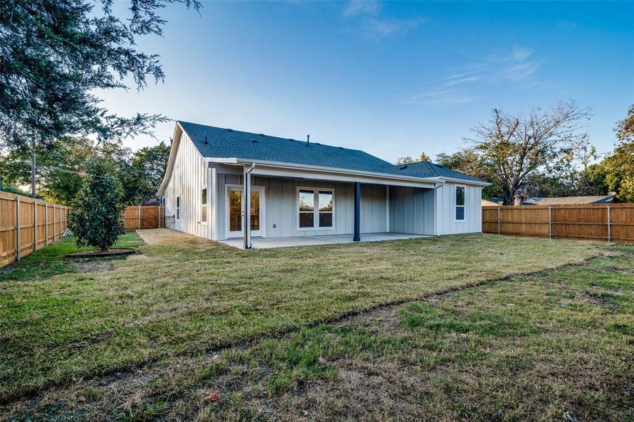 Rear view of property featuring a patio and a lawn