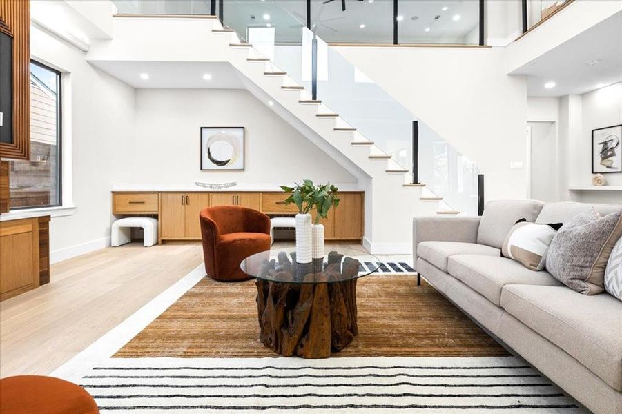 Living room with hardwood / wood-style floors and a towering ceiling