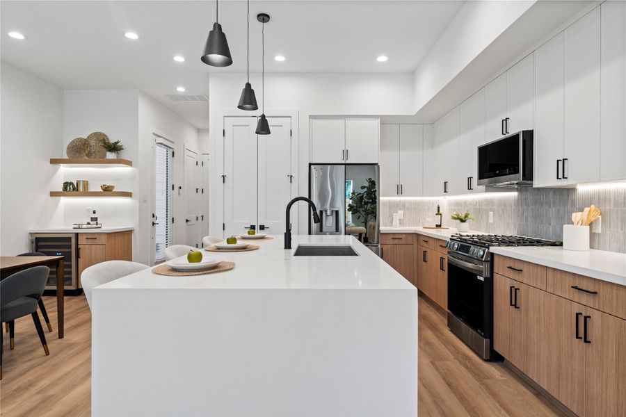 An expansive kitchen and dining area anchors the home, showcasing a massive quartz island with a farmhouse-style sink. The open layout is equal parts functional and stylish—perfect for everyday living or entertaining An expansive kitchen and dining area anchors the home, showcasing a massive quartz island with a farmhouse-style sink. The open layout is equal parts functional and stylish—perfect for everyday living or entertaining