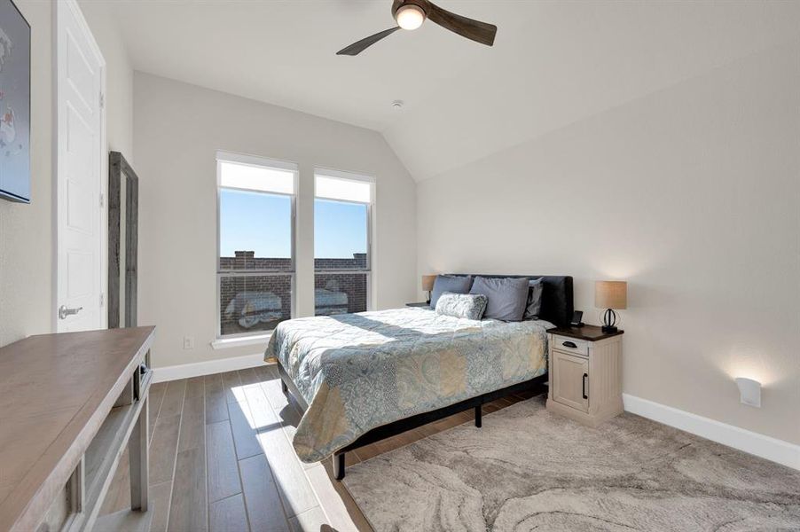 Large Walk in shower and walk in closet with this ensuite bath.  Second Primary Bedroom is perfect for welcoming overnight guests in this 15' x 11' bedroom with wood look tile floors, ceiling fan for comfort and separate from other rooms in the house. Custom roller shades allow them to sleep late if they want.