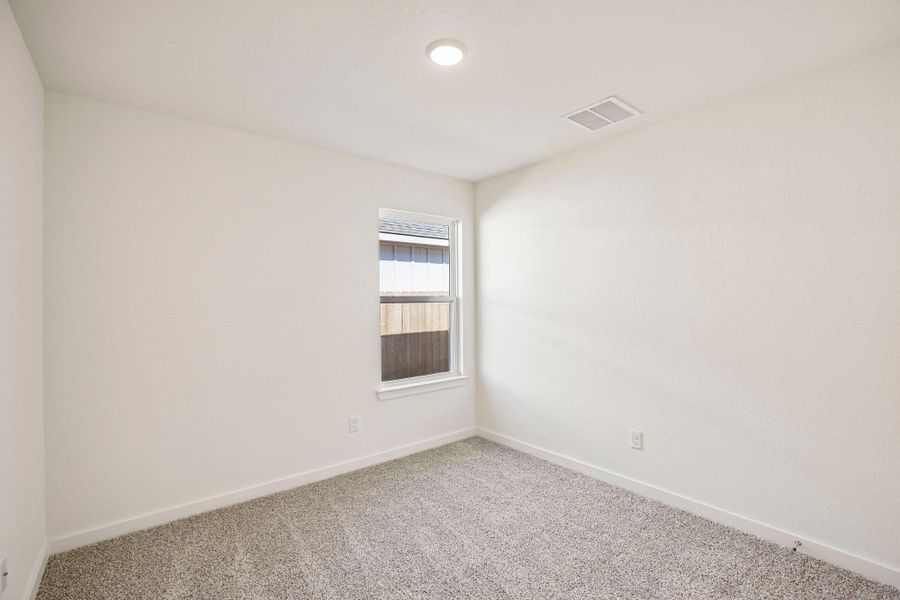 Plush carpeting and natural light define this clean, versatile bedroom space.