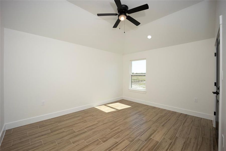 Empty room featuring recessed lighting, wood tiled floors, lofted ceiling, and ceiling fan