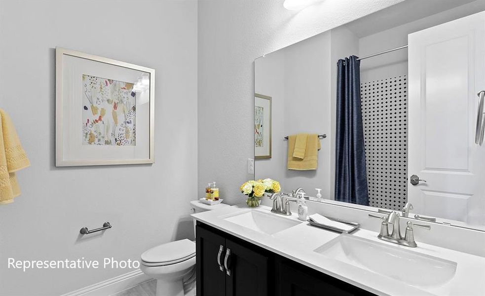 Bathroom with double vanity and a shower with shower curtain