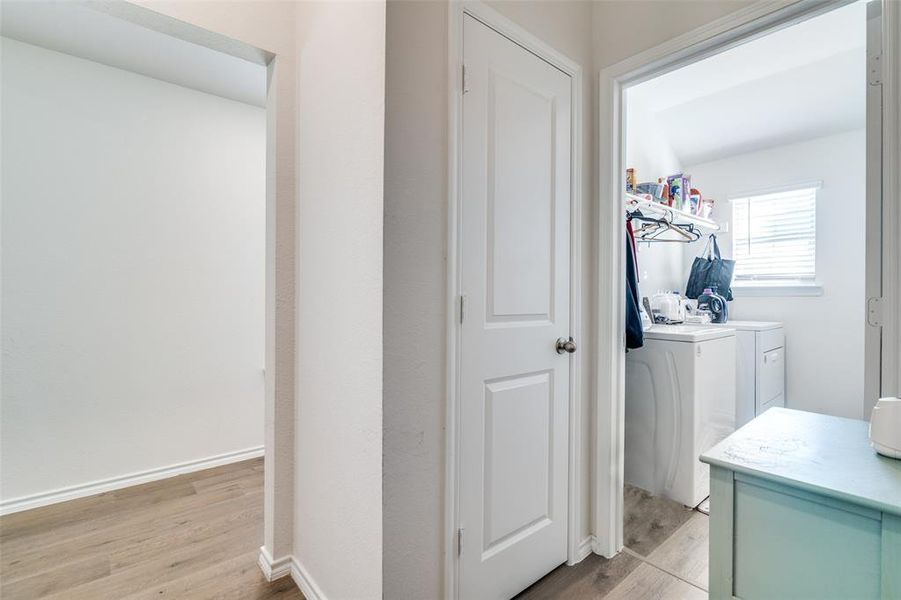 Laundry area with light wood-type flooring, laundry area, baseboards, and washer and dryer