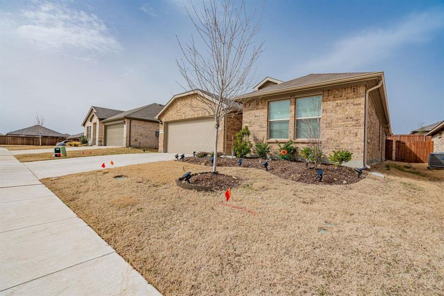 Ranch-style house with a garage, brick siding, concrete driveway, and fence