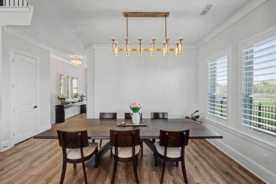 The formal dining room is large enough for a table with comfortable seating for eight, and it's illuminated by a sophisticated multi-bulb brass chandelier. Large windows with built-in shutters provide natural light and views of the surrounding neighborhood.