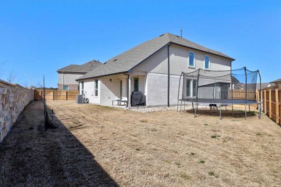 Back of house with a fenced backyard, and brick siding