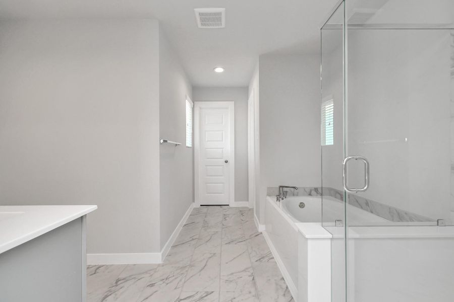 Indulge in a spa-like retreat within the confines of this primary bathroom. Delight in a spacious walk-in shower enveloped in stylish tile surround, unwind in a separate garden tub adorned with custom detailing. Sample photo of completed home with similar floor plan. Actual colors and selections may vary. Indulge in a spa-like retreat within the confines of this primary bathroom. Delight in a spacious walk-in shower enveloped in stylish tile surround, unwind in a separate garden tub adorned with custom detailing. Sample photo of completed home with similar floor plan. Actual colors and selections may vary.