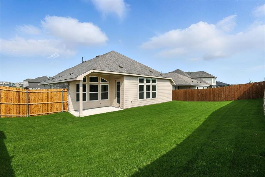 Rear view of house with a fenced backyard, a patio, and roof with shingles