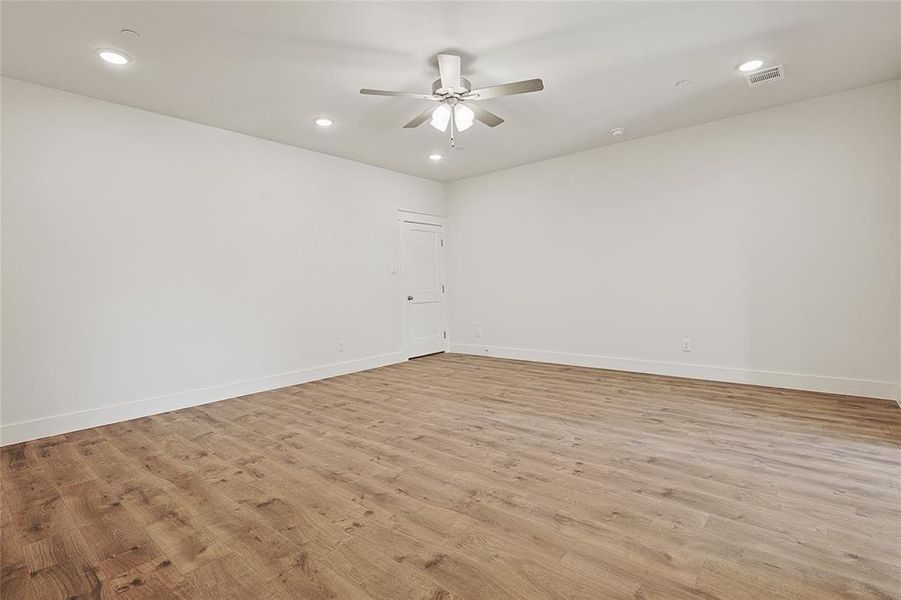 Unfurnished room with ceiling fan and light wood-type flooring