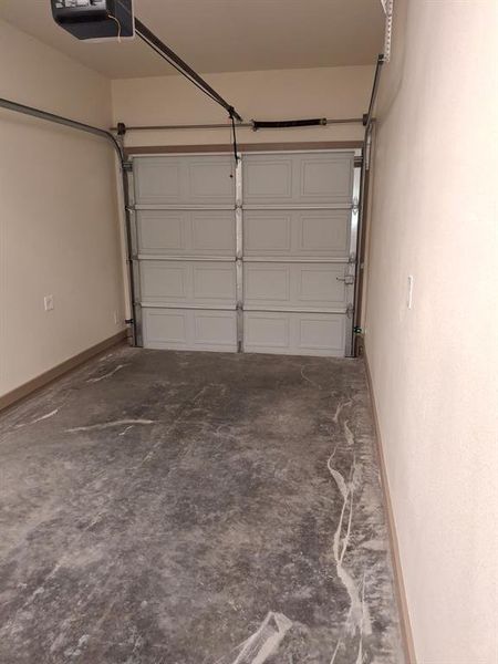 Garage with a garage door opener and baseboards Garage with a garage door opener and baseboards
