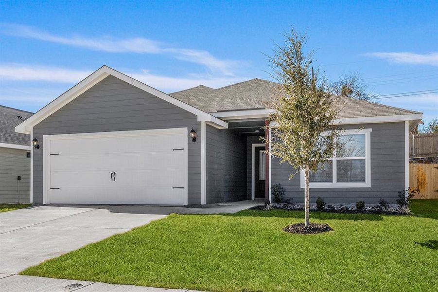 Ranch-style home featuring a front yard and a garage