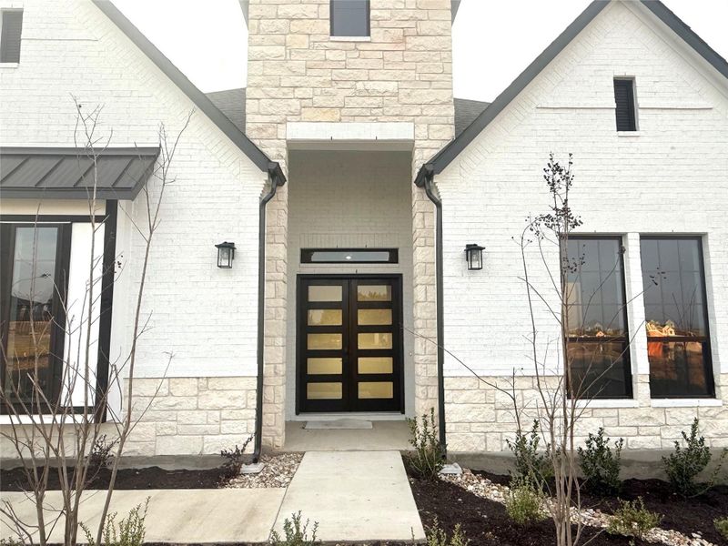 Entrance to property with stone siding and brick siding