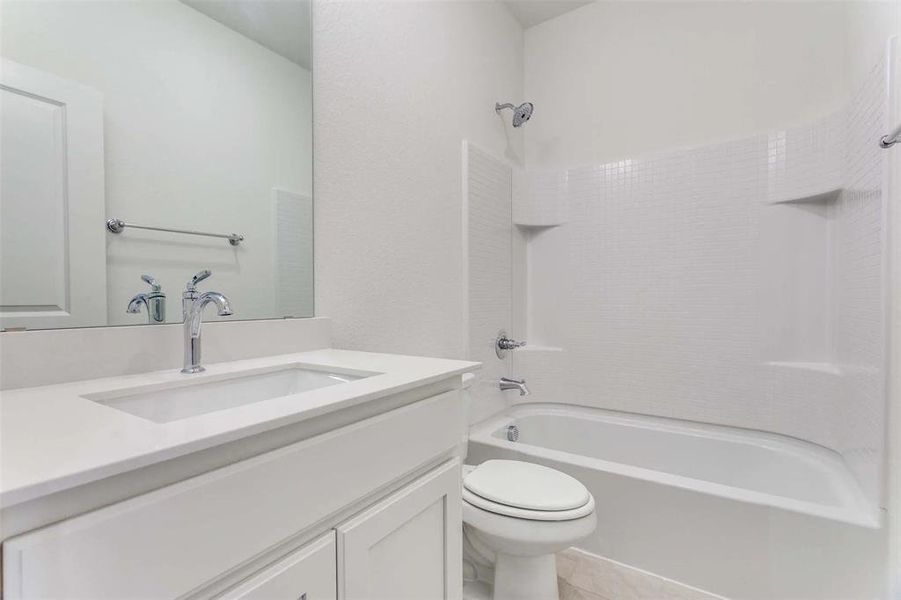 Bathroom featuring toilet, bathtub / shower combination, vanity, and tile patterned floors