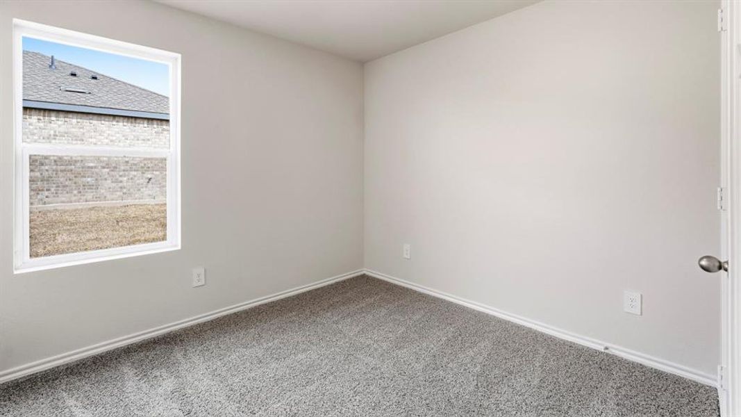 Carpeted spare room featuring baseboards