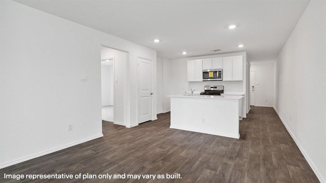 Kitchen with light countertops, a kitchen island with sink, white cabinets, dark wood-style flooring, and appliances with stainless steel finishes