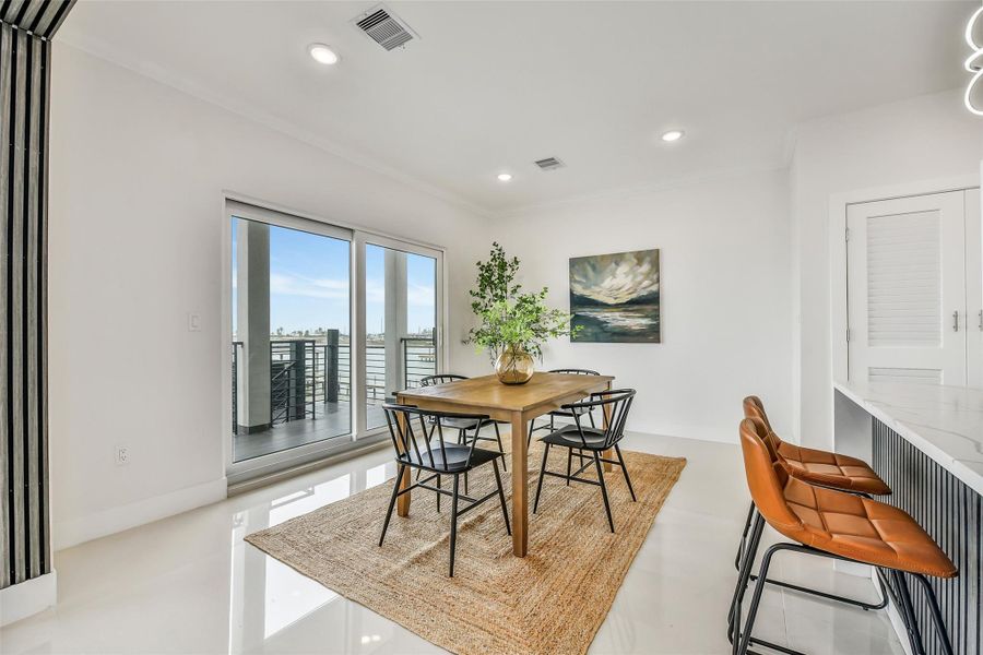 Every meal comes with a front-row bay view. The dining area connects naturally to the waterfront porch, making indoor and outdoor entertaining feel effortless. Every meal comes with a front-row bay view. The dining area connects naturally to the waterfront porch, making indoor and outdoor entertaining feel effortless.