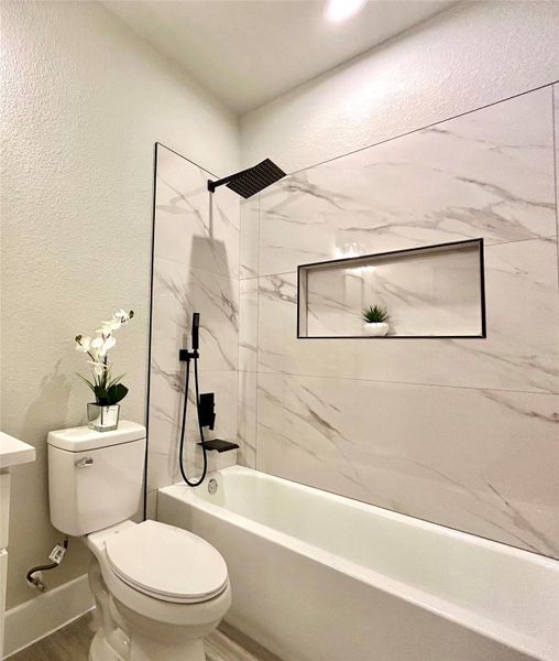 Secondary bathroom with soak in tub and spray handle.