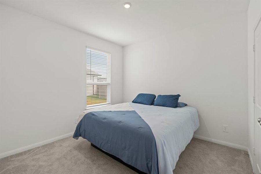 Striking Secondary bedroom on second floor featuring plush carpet, neutral finishes and easy access to the Flex Space and bathroom.