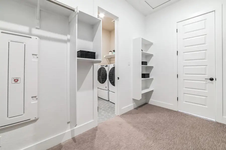 Laundry room featuring separate washer and dryer and light colored carpet