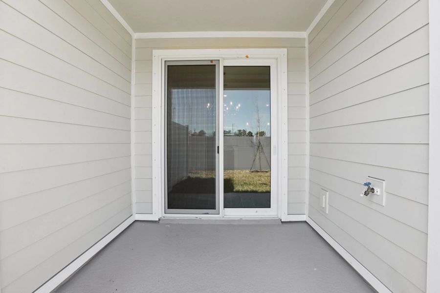 Spacious covered lanai with sliding glass doors located at the back of the home