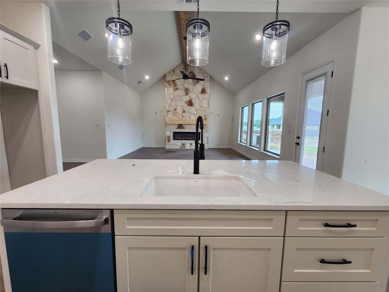 Kitchen island with an undermount sink, a gooseneck faucet, and light-toned countertops