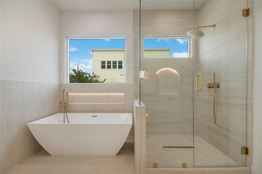 Bathroom featuring a stall shower, tile walls, and a freestanding tub