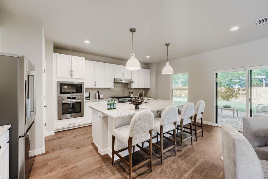 A well-appointed kitchen features a central island, modern appliances, and seamless outdoor access. A well-appointed kitchen features a central island, modern appliances, and seamless outdoor access.