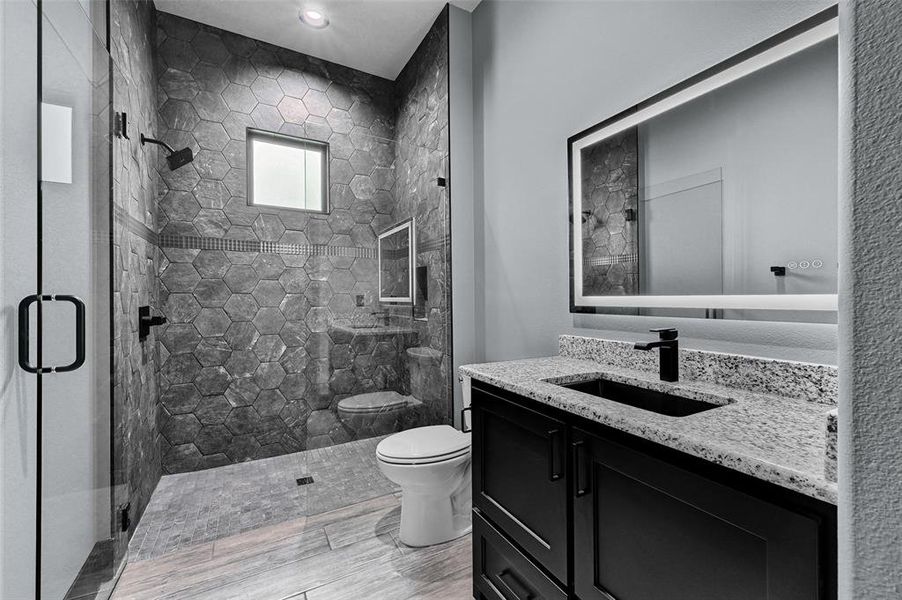 Bathroom with toilet, vanity, and a shower stall Bathroom with toilet, vanity, and a shower stall