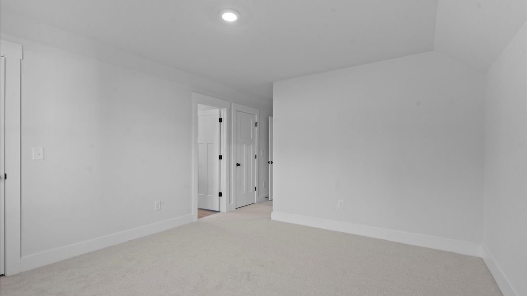 Notable secondary bedroom offering cozy carpeted flooring and a stylish walk-in closet
