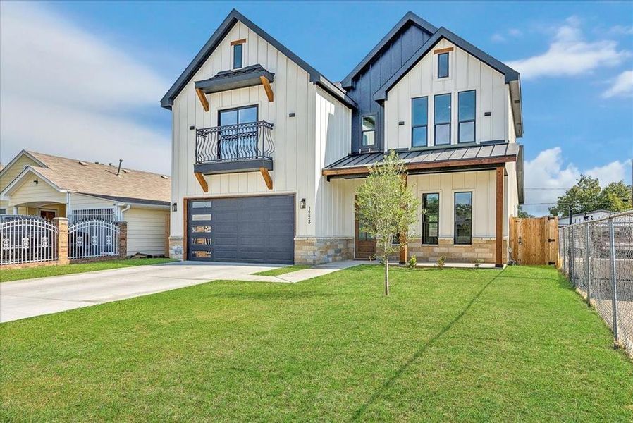 Modern farmhouse style home with board and batten siding, driveway, a standing seam roof, and a gate