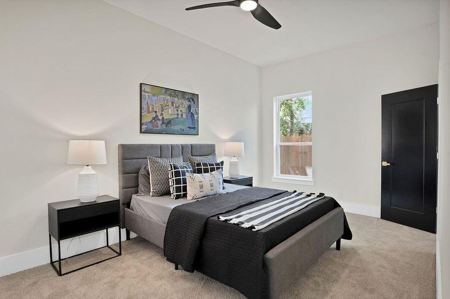 Bedroom with ceiling fan and light carpet