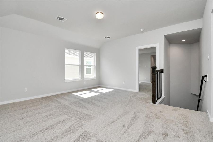 Ascend to relaxation in this fantastic game room! Ideal for both casual gatherings and adult gaming, it boasts plush carpet, lofty ceilings, custom paint, and ample windows for abundant natural light.