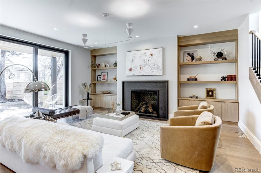 Spacious living space with sliders to the exterior, gas fireplace and built-ins