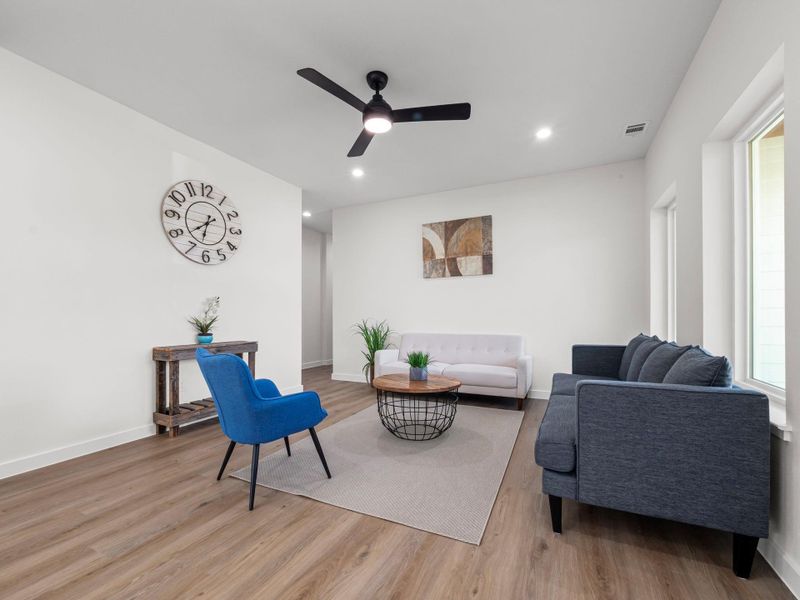 Living space featuring light wood-finish flooring, recessed lighting, and a contemporary ceiling fan