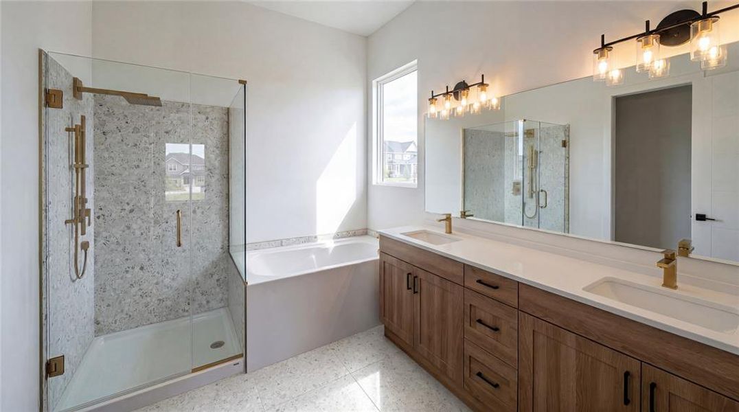 Modern bathroom featuring a dual vanity with wood-finish cabinetry, white countertops, and gold-tone fixtures Modern bathroom featuring a dual vanity with wood-finish cabinetry, white countertops, and gold-tone fixtures