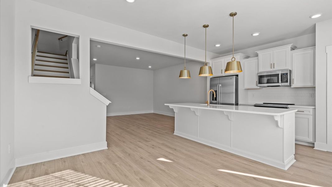 Tasteful design meets functional luxury in this kitchen with a 9-foot island and modern pendant lighting