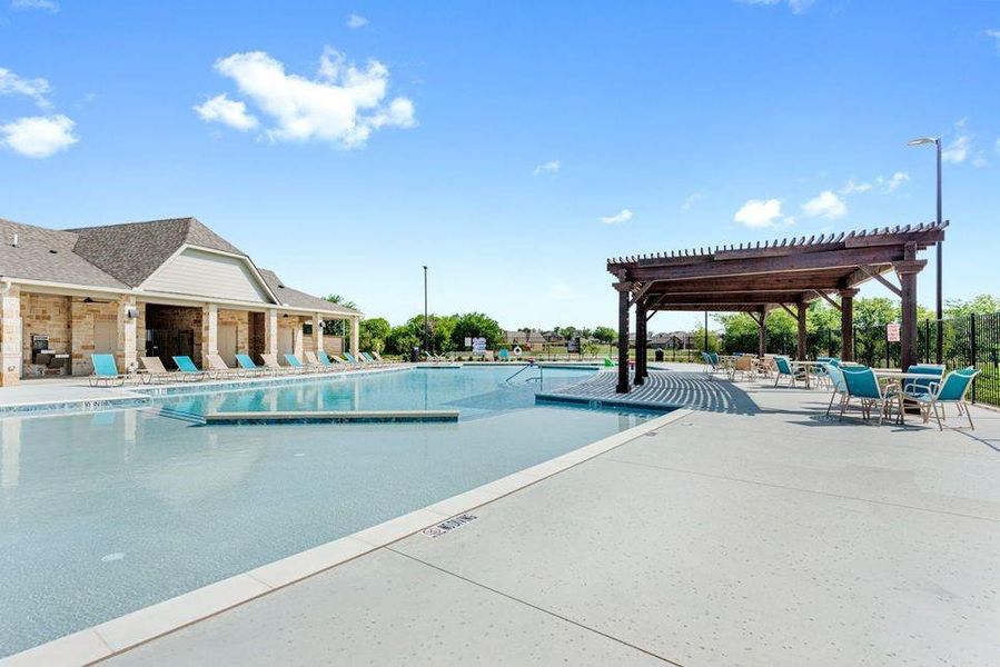 Community swimming pool with an integrated sun shelf, a dedicated children's area, and surrounding concrete decking