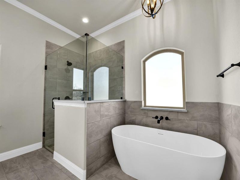 Bathroom with ornamental molding and shower with separate bathtub