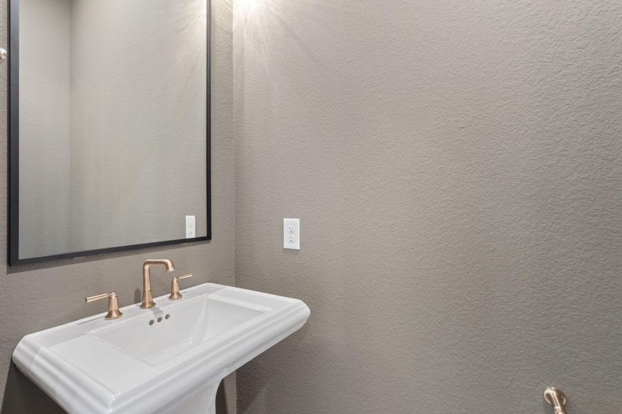 Elegant pedestal sink in the powder room, situated off the foyer