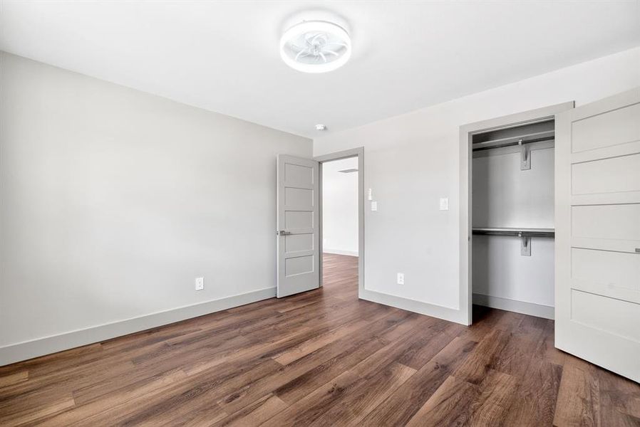Unfurnished bedroom featuring dark wood-style floors and a closet Unfurnished bedroom featuring dark wood-style floors and a closet