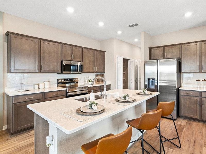 Your beautiful kitchen includes quartz and high-end finishes, with either warm and cozy wood cabinets... - Mariposa townhome by Highland Homes Your beautiful kitchen includes quartz and high-end finishes, with either warm and cozy wood cabinets... - Mariposa townhome by Highland Homes