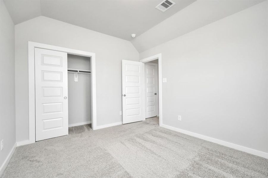 Generously sized secondary bedrooms featuring spacious closets, soft and inviting carpeting underfoot, large windows allowing plenty of natural light, and the added touch of privacy blinds for your personal retreat. Sample photo of completed home with similar floor plan. As-built interior colors and selections may vary.