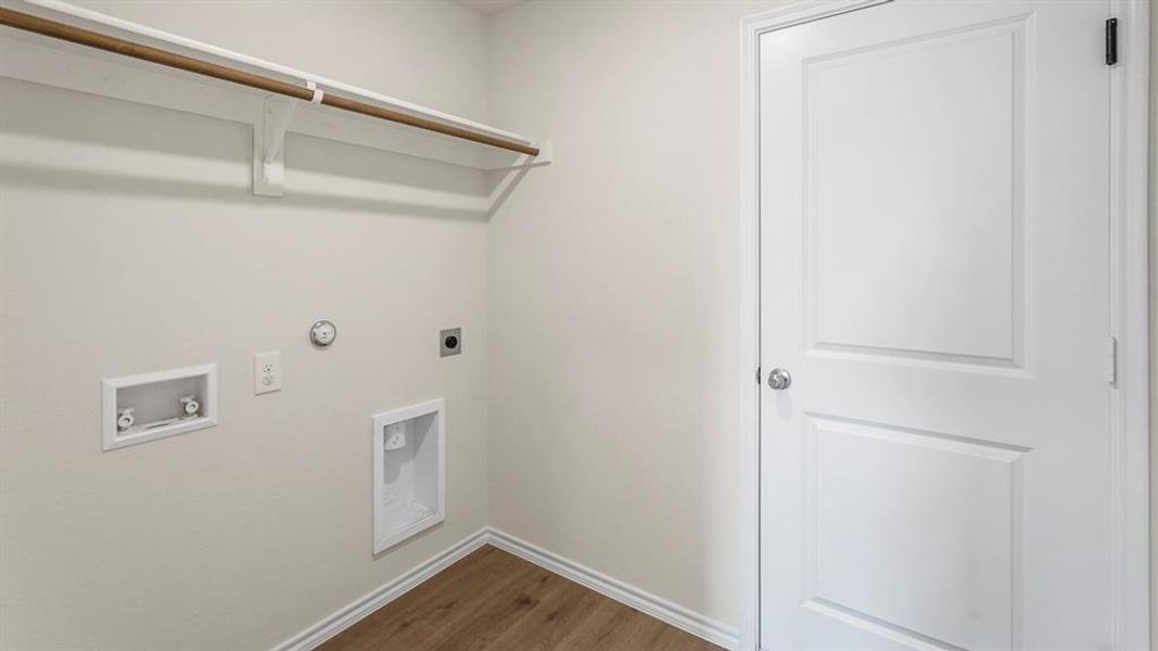 Dedicated utility space featuring wood-finish flooring and a neutral color palette