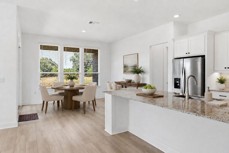 Virtually staged. A seamless open floorplan combines kitchen and dining, featuring generous granite counter space and luminous hardwood floors. Virtually staged. A seamless open floorplan combines kitchen and dining, featuring generous granite counter space and luminous hardwood floors.